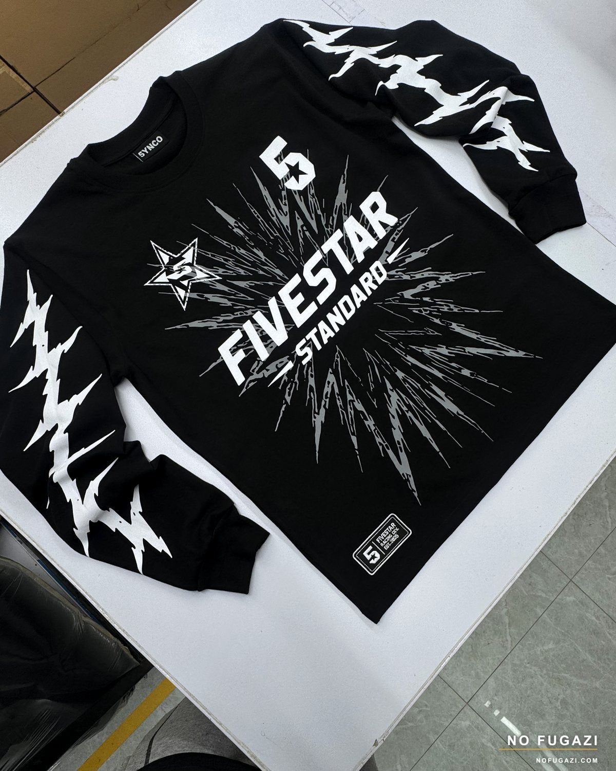 Black long-sleeve tee with a screen-printed graphic across the chest and both sleeves